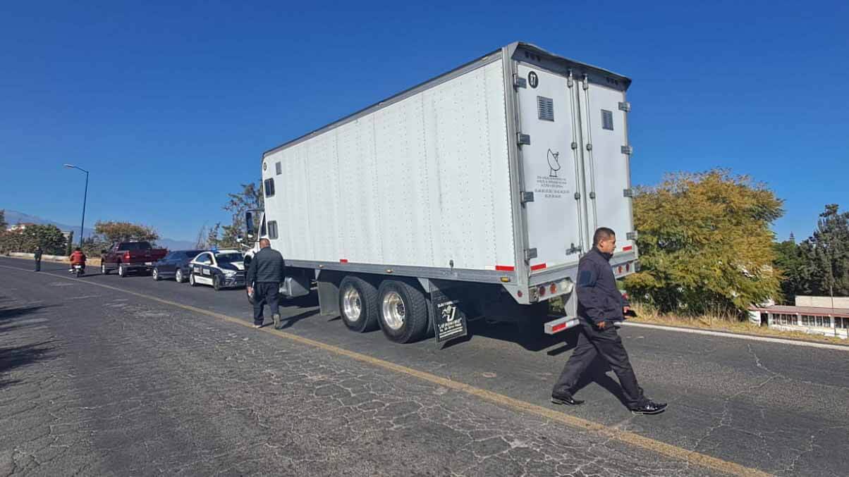 Conductor y camión con remolque al costado de la carretera